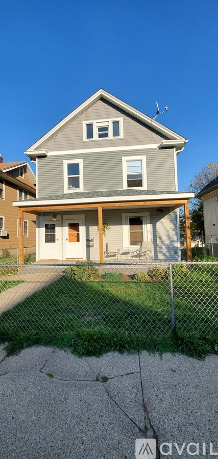 A house with a grey roof and a brown fence.