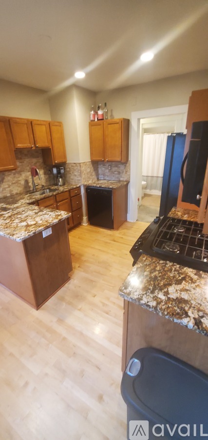 A kitchen with granite countertops and wooden cabinets.