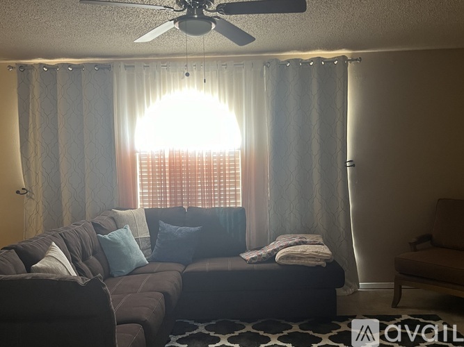 A living room with a couch and a ceiling fan.