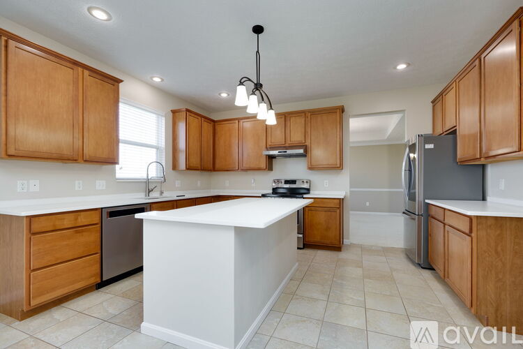 A kitchen with wooden cabinets and a white island.