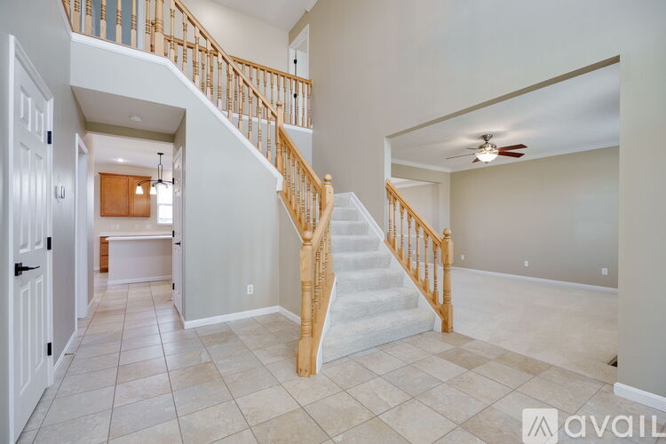 A spacious living room with a staircase leading to the upper floor.