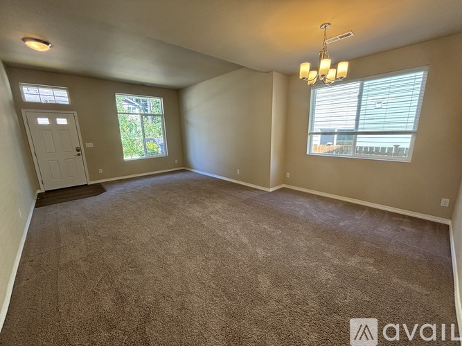 A room with a carpeted floor and a window with blinds.