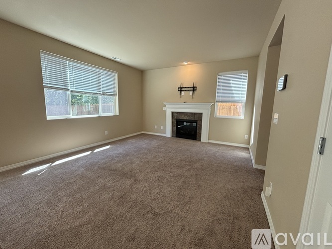 A living room with a fireplace and a carpeted floor.