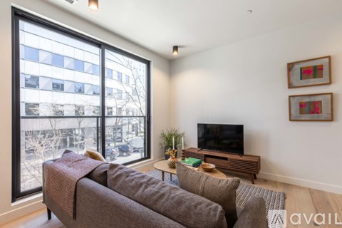 A living room with a grey couch and a television.