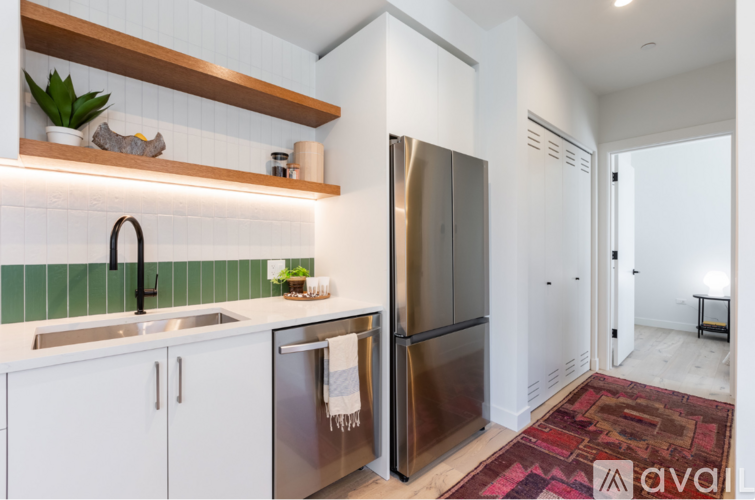 A modern kitchen with stainless steel appliances and white cabinets.