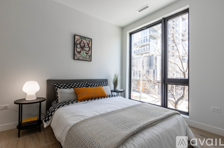 A bedroom with a large bed and a window overlooking a city.