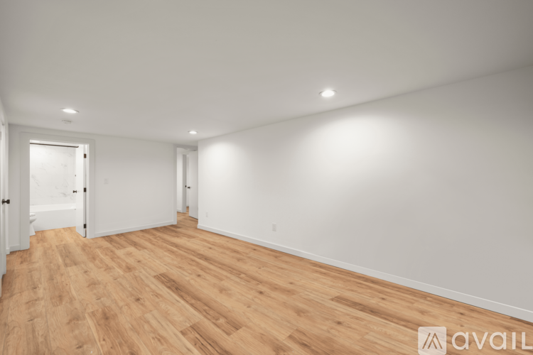 A room with wooden flooring and white walls.