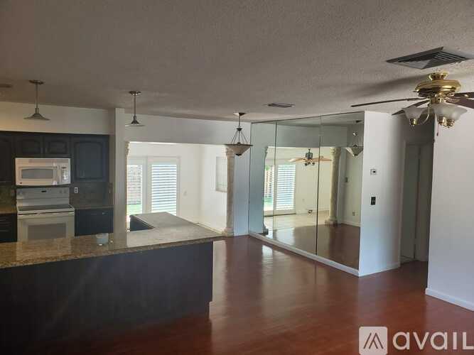 A kitchen with a dark countertop and a microwave on it.