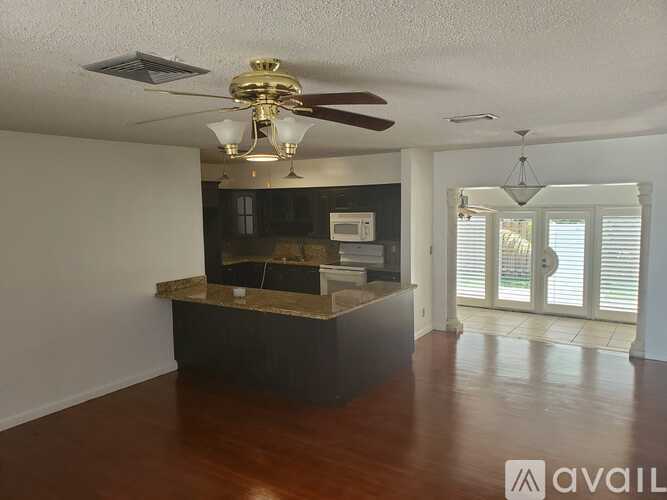 A room with a ceiling fan and a counter.