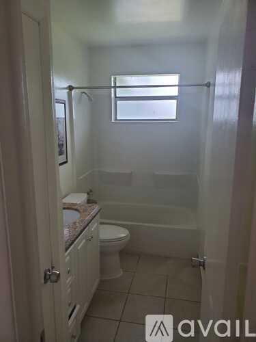 A bathroom with a toilet, sink and shower.
