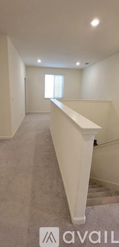 A spacious room with a staircase leading to the second floor.