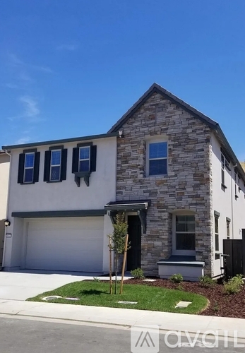 A house with a stone facade and a garage door.