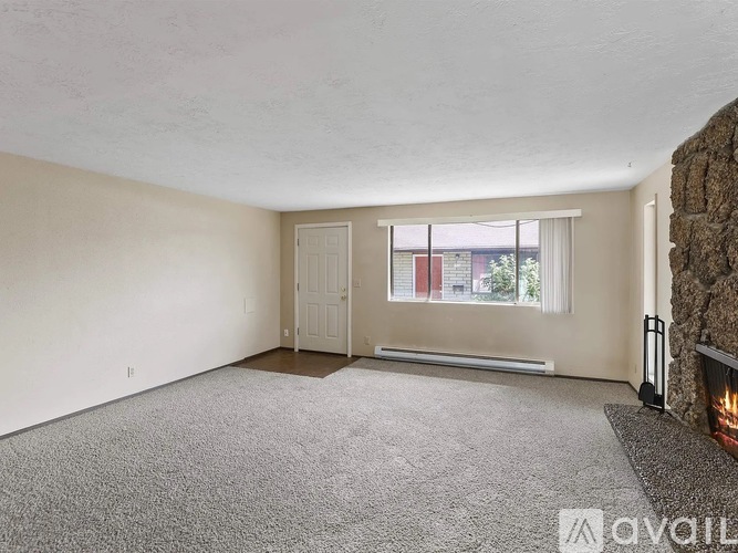 A living room with a fireplace and a carpeted floor.