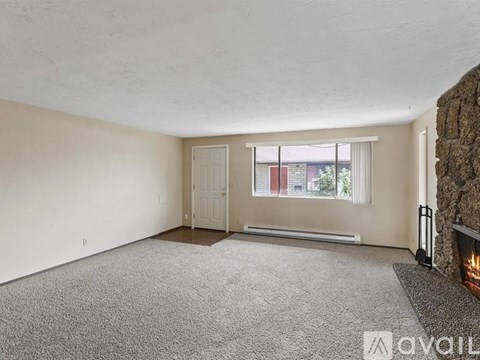 A living room with a fireplace and a carpeted floor.