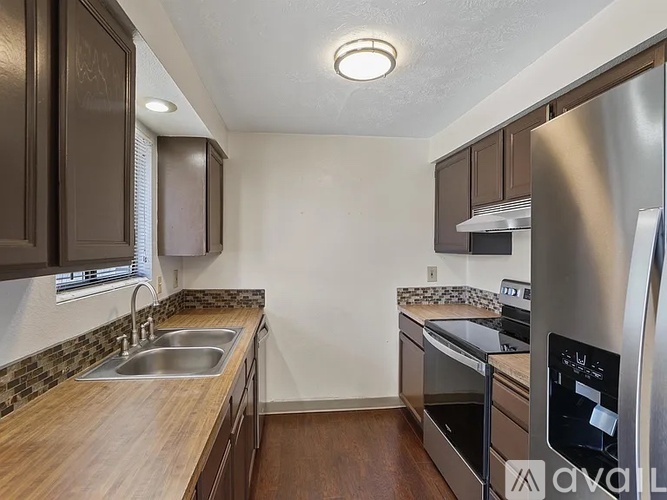 A kitchen with a sink, stove, and refrigerator.