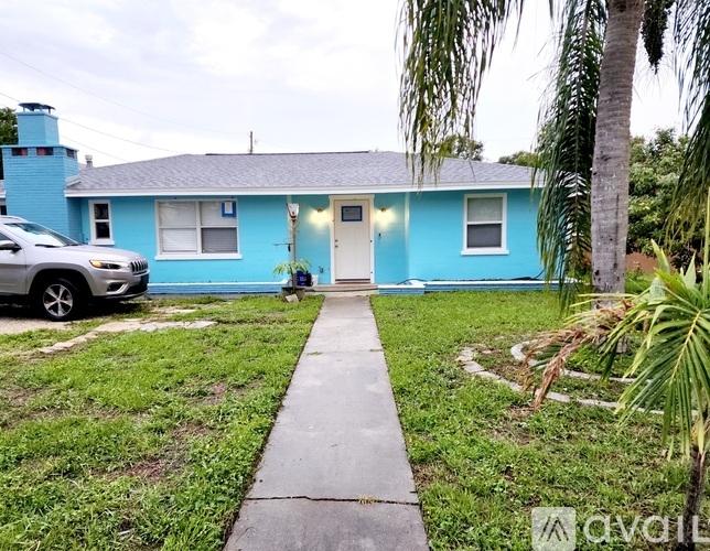 A blue house with a white door and a small porch.