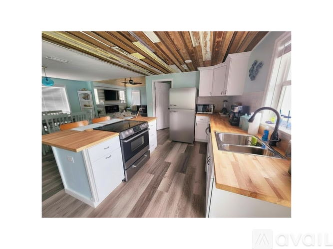 A kitchen with wooden floors and a wooden ceiling.