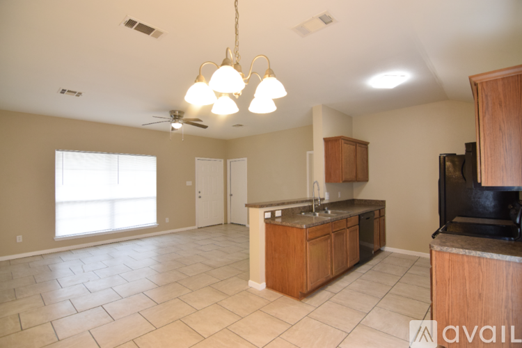 A kitchen with wooden cabinets and a black countertop.