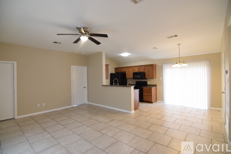 A spacious living room with a ceiling fan and a television.