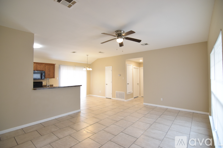 A spacious room with a ceiling fan and tiled flooring.