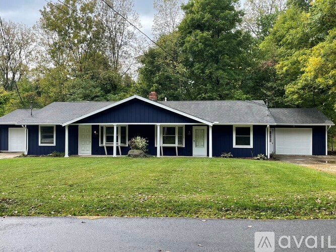 A blue house with a white door and windows is for sale.