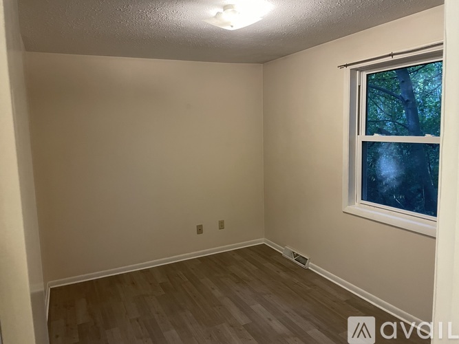 A room with a window and wooden flooring.