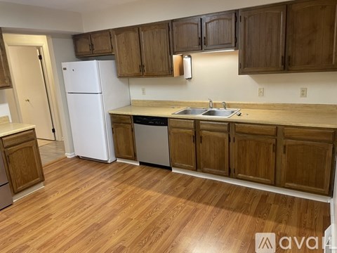 A kitchen with wooden cabinets and a white refrigerator.