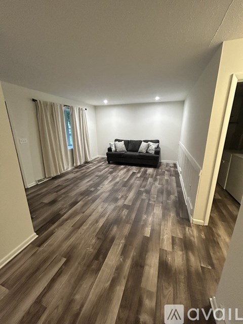 A living room with a couch and a wooden floor.