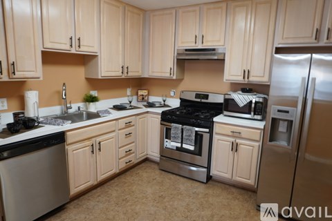 A kitchen with wooden cabinets and stainless steel appliances.