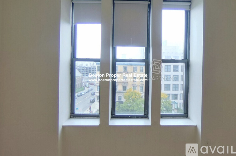 Three windows looking out onto a city street.