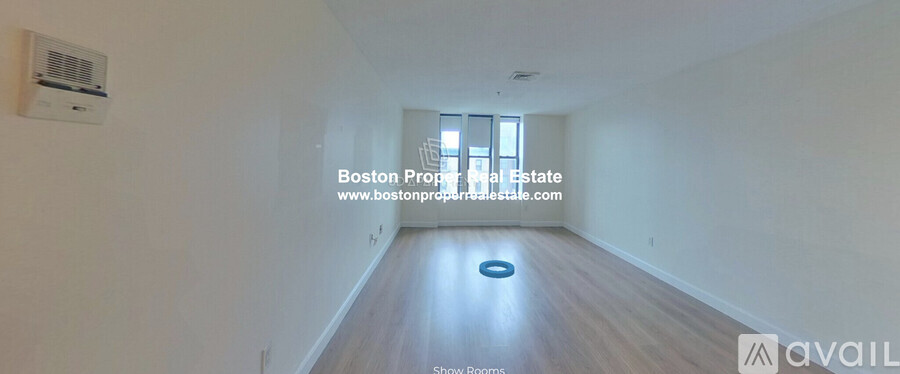 A long, empty hallway with a window and a blue circular object on the floor.