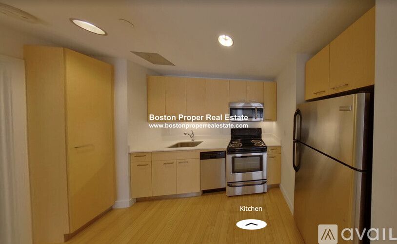 A kitchen with wooden cabinets and a stainless steel refrigerator is available for rent.