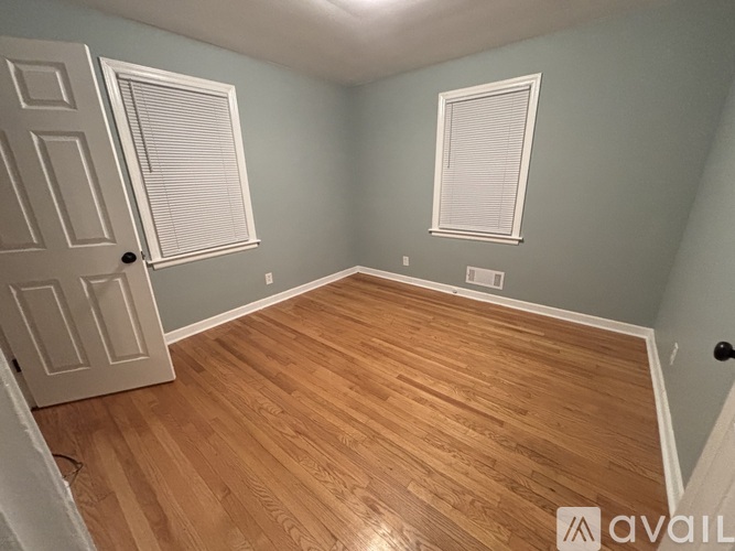 A room with wooden flooring and a white door.