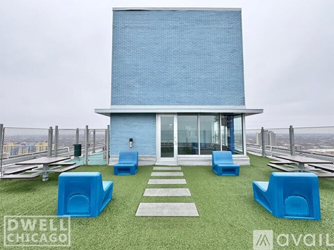 A modern house with a blue exterior and a green lawn.