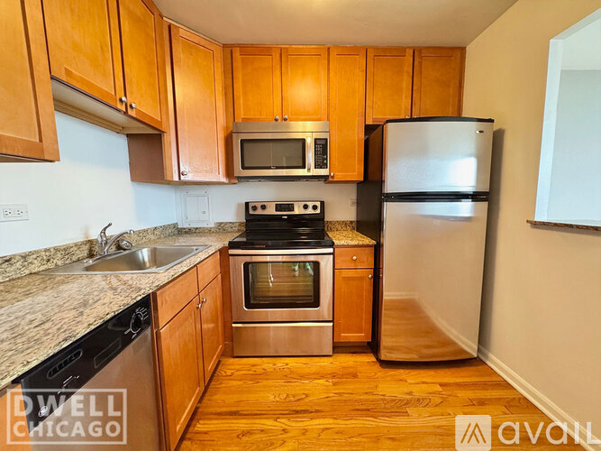 A kitchen with wooden cabinets and a stainless steel refrigerator.