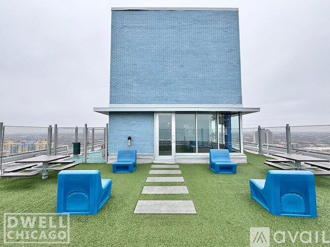 A modern house with a blue exterior and a green lawn.