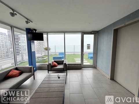 A living room with a couch and a television with a Dwell Chicago logo.