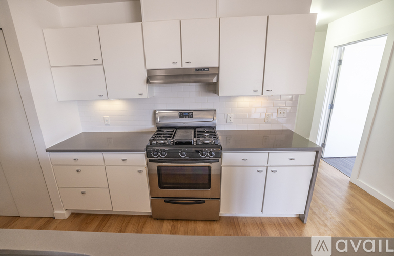 A modern kitchen with white cabinets and stainless steel appliances.