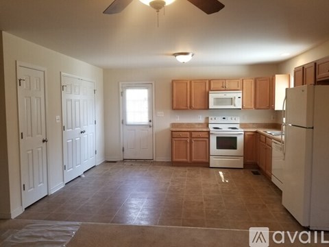 A kitchen with brown cabinets and white appliances.