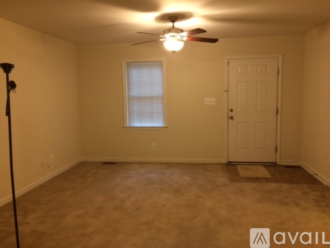 A room with a ceiling fan and a door.