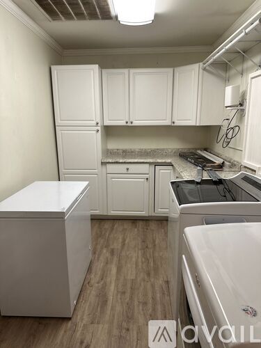 A kitchen with white cabinets and a white dishwasher.