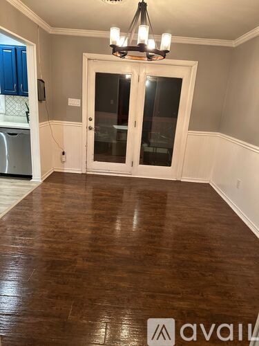 A room with a wooden floor and a chandelier.