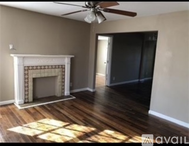 A room with a fireplace and a ceiling fan.