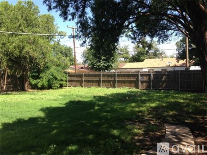 A backyard with a fence and trees.