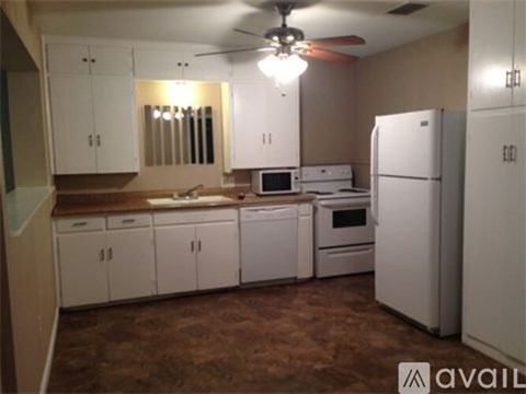 A kitchen with white appliances and cabinets.