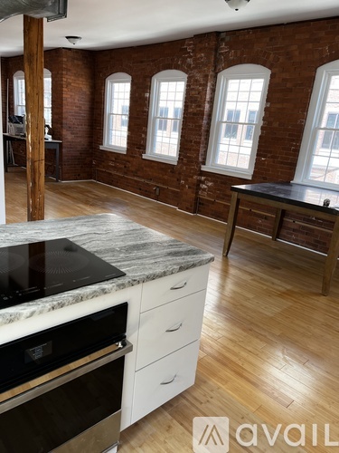 A kitchen with a marble countertop and white cabinets.