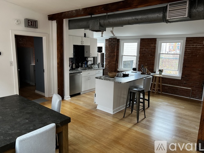 A kitchen with a black counter top and white cabinets.