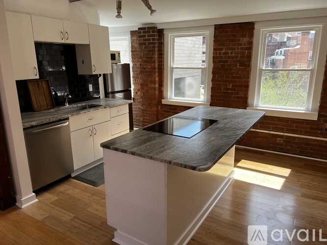 A kitchen with a brick wall and a marble countertop.