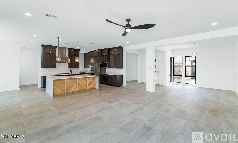 A spacious living room with a wooden counter and a ceiling fan.