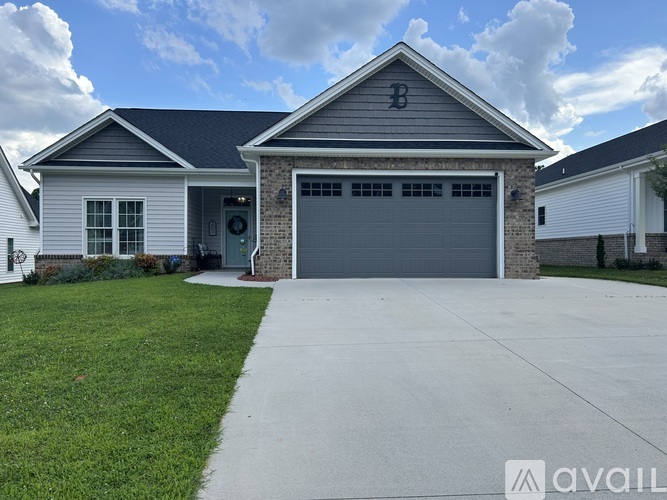 A house with a grey garage door and a driveway in front.